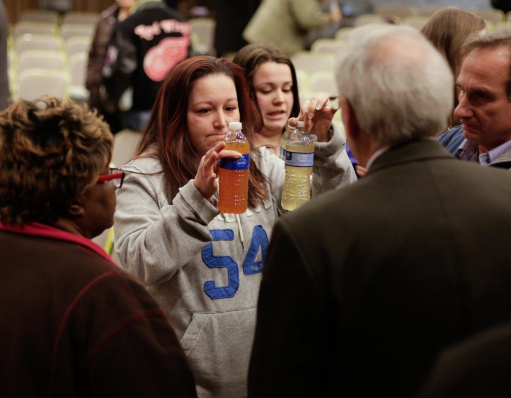 LeeAnne Walters of Flint, Michigan, shows water samples from her home from January 21, 2015 and January 15, 2015 to Flint's emergency manager Jerry Ambrose after city and state officials spoke during a forum discussing growing health concerns being raised by Flint residents at the Flint City Hall dome on January 21, 2015. (Credit Image: © Ryan Garza/Detroit Free Press via ZUMA Wire)